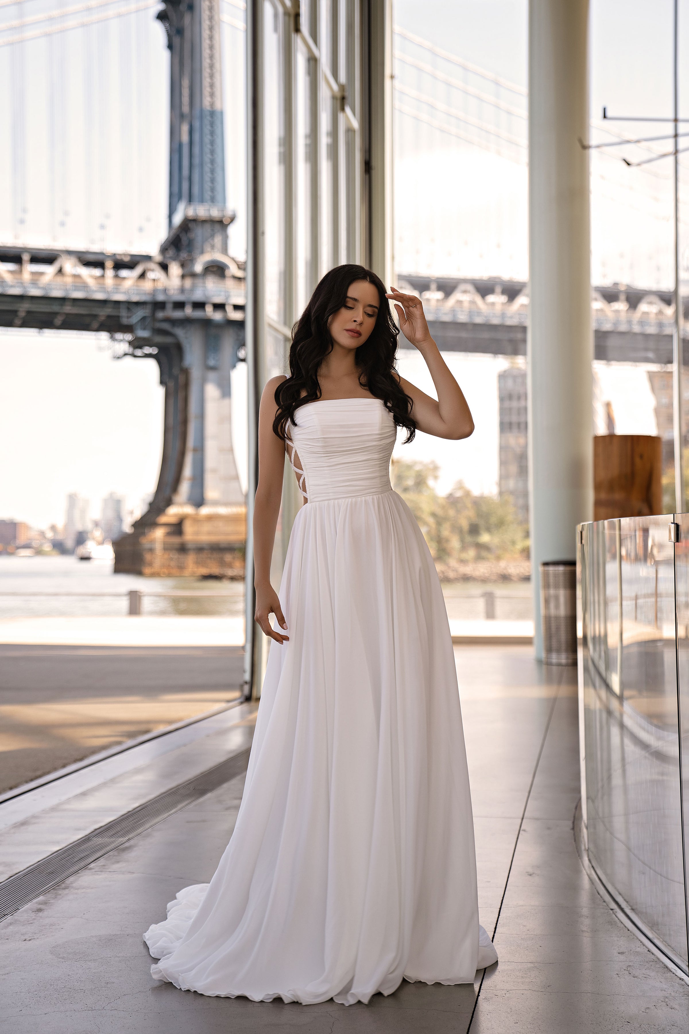 Ivory A-line wedding dress with a straight neckline, ruched strapless bodice, and flowing train