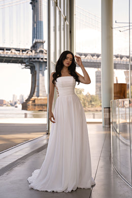 Ivory A-line wedding dress with a straight neckline, ruched strapless bodice, and flowing train