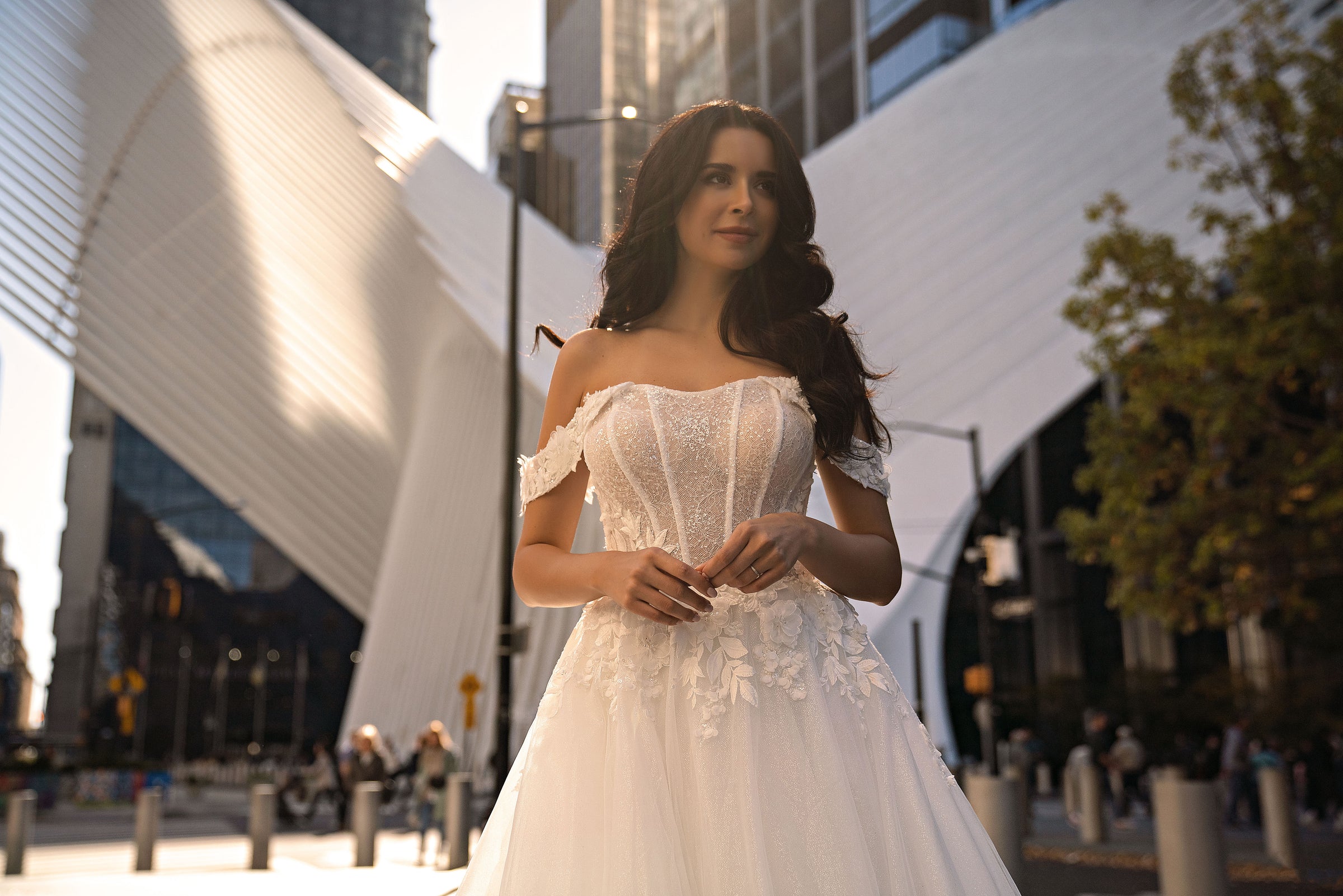 Embellished ivory wedding dress featuring a corset-style bodice, off-the-shoulder neckline, and full skirt