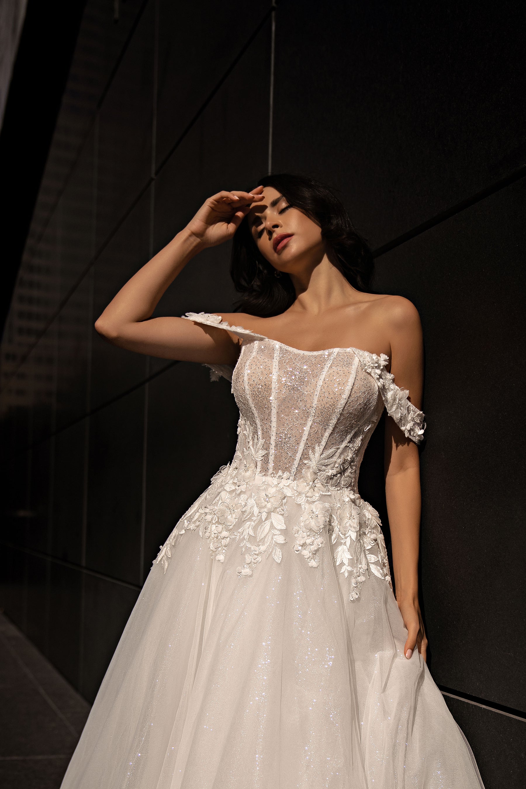 Ivory A-line wedding dress with a beaded off-the-shoulder bodice and floral appliqués across the waist