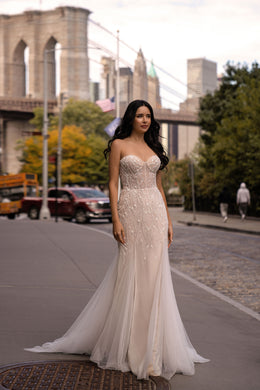Ivory strapless mermaid wedding dress with a beaded bodice and sweeping tulle train
