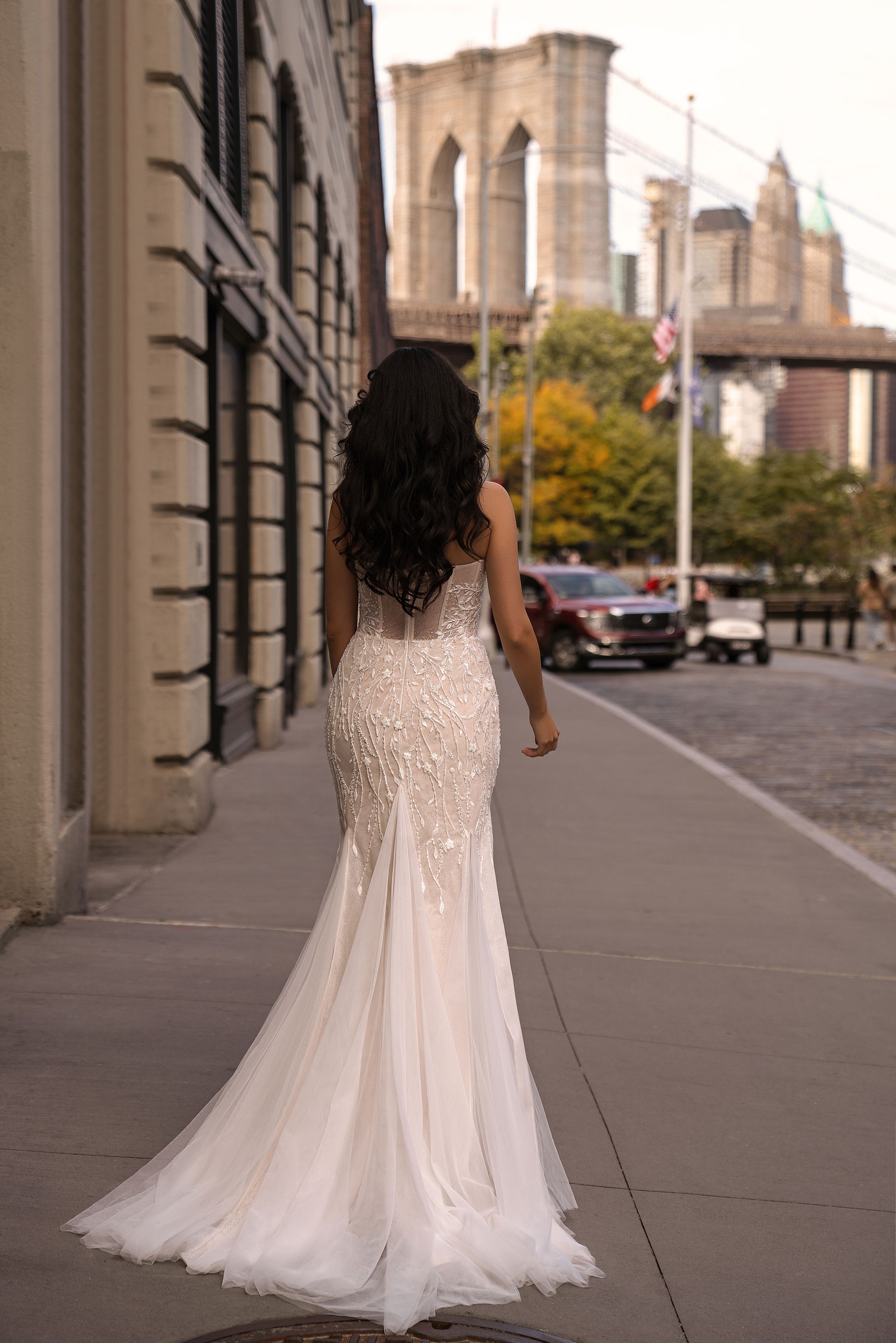 Beaded strapless back and fitted mermaid silhouette on an ivory wedding dress with a flowing train