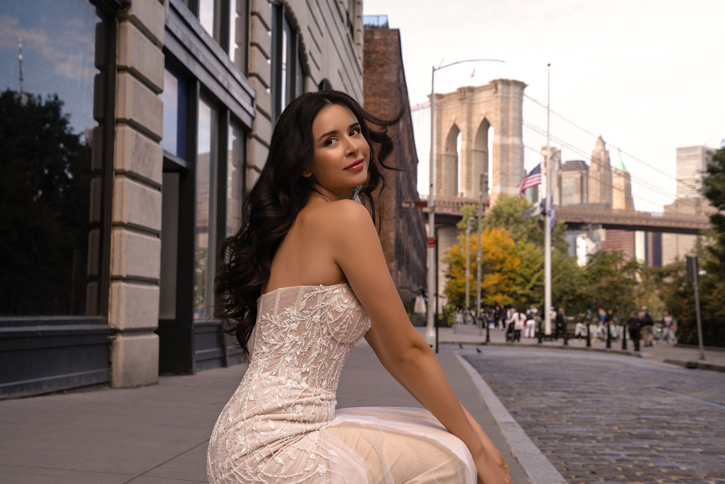 Side-back view of an ivory strapless wedding dress with a sparkling beaded bodice and mermaid skirt