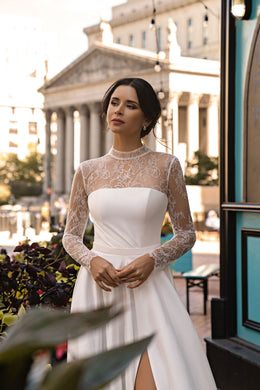 White A-line wedding dress with a high lace neckline, long lace sleeves, and a sweetheart bodice