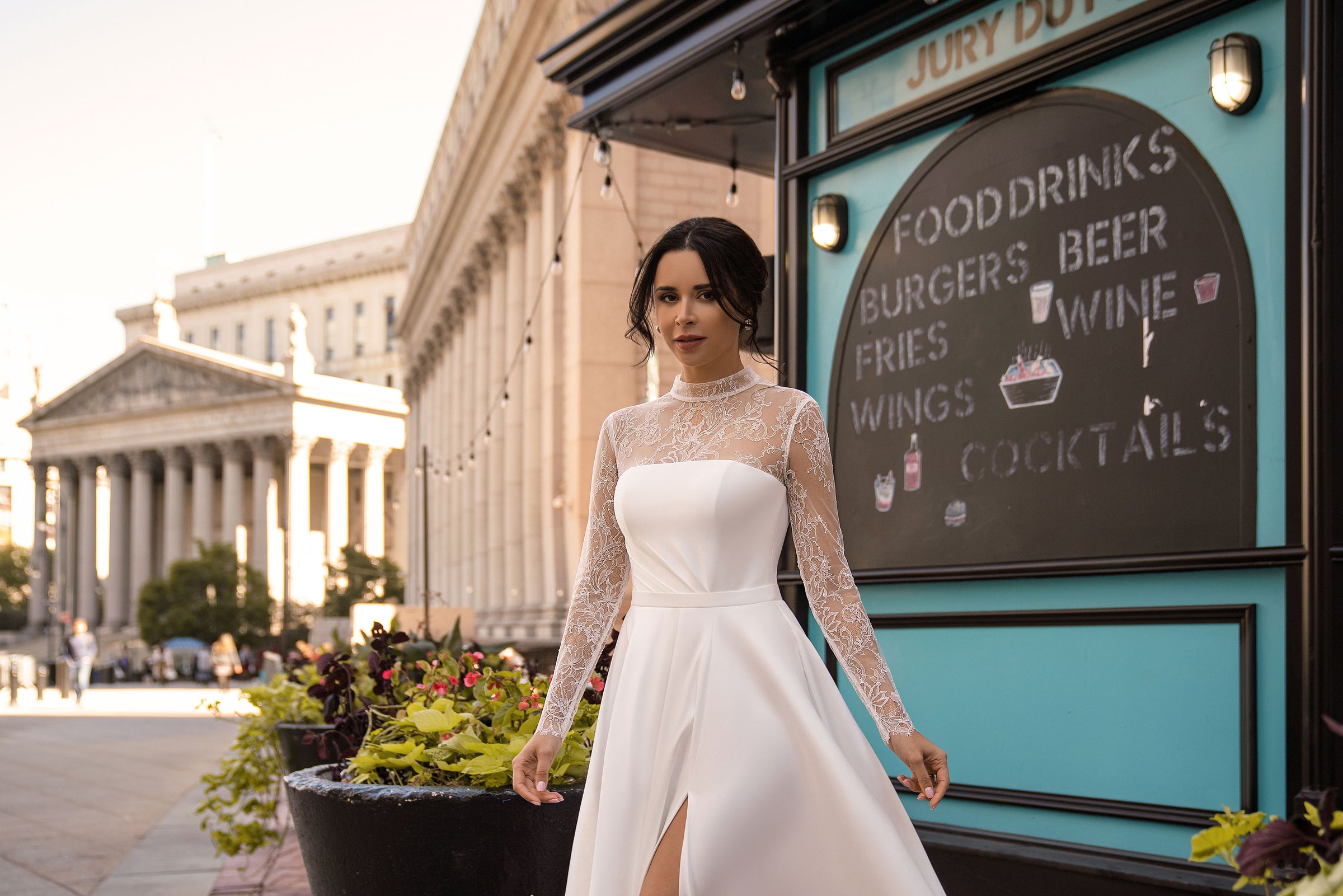 High-neck white wedding dress featuring floral lace sleeves, a smooth bodice, and a front skirt slit