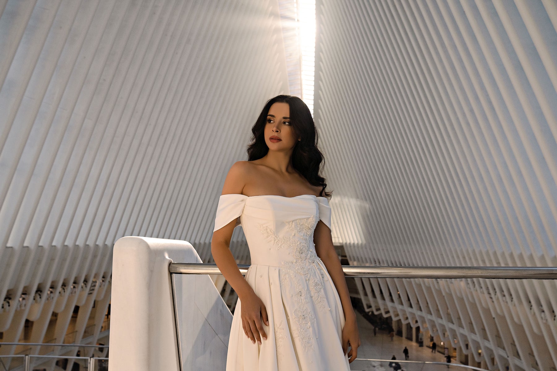 Ivory wedding dress featuring an off-the-shoulder neckline and a close-up view of its sparkling embellished bodice