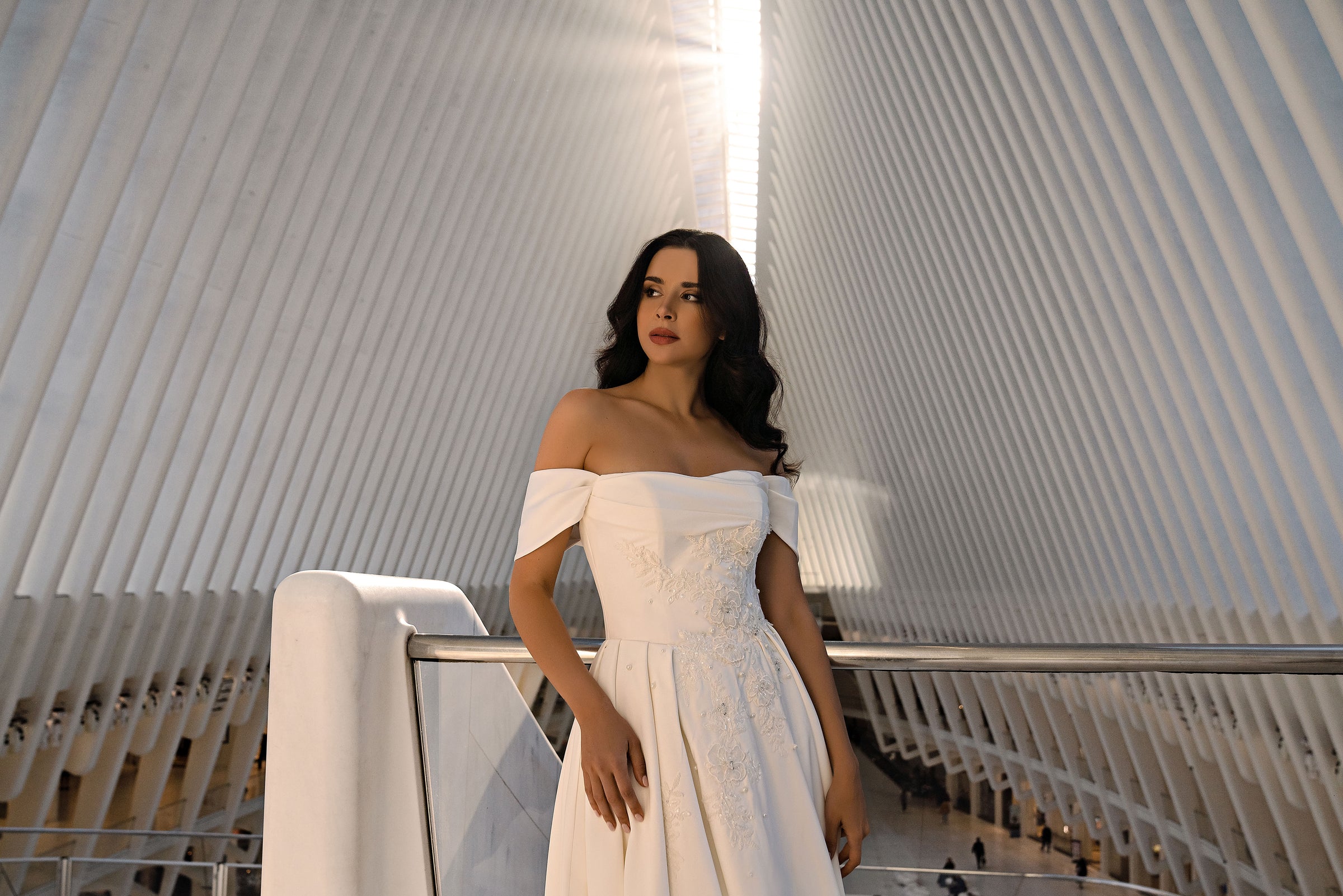 Ivory wedding dress featuring an off-the-shoulder neckline and a close-up view of its sparkling embellished bodice
