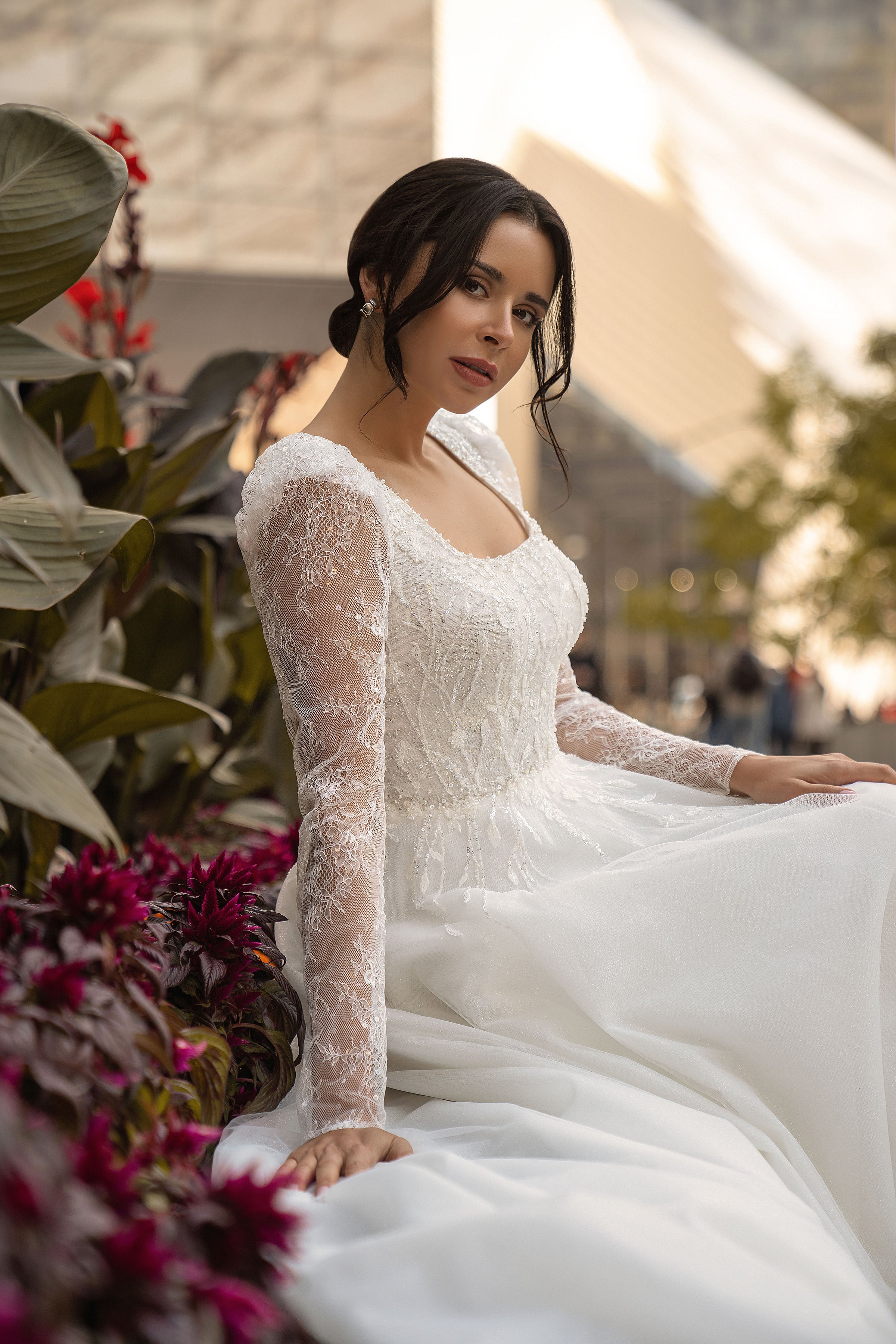 Ivory wedding dress with a beaded lace bodice, scoop neckline, sheer floral lace sleeves, and flowing tulle skirt