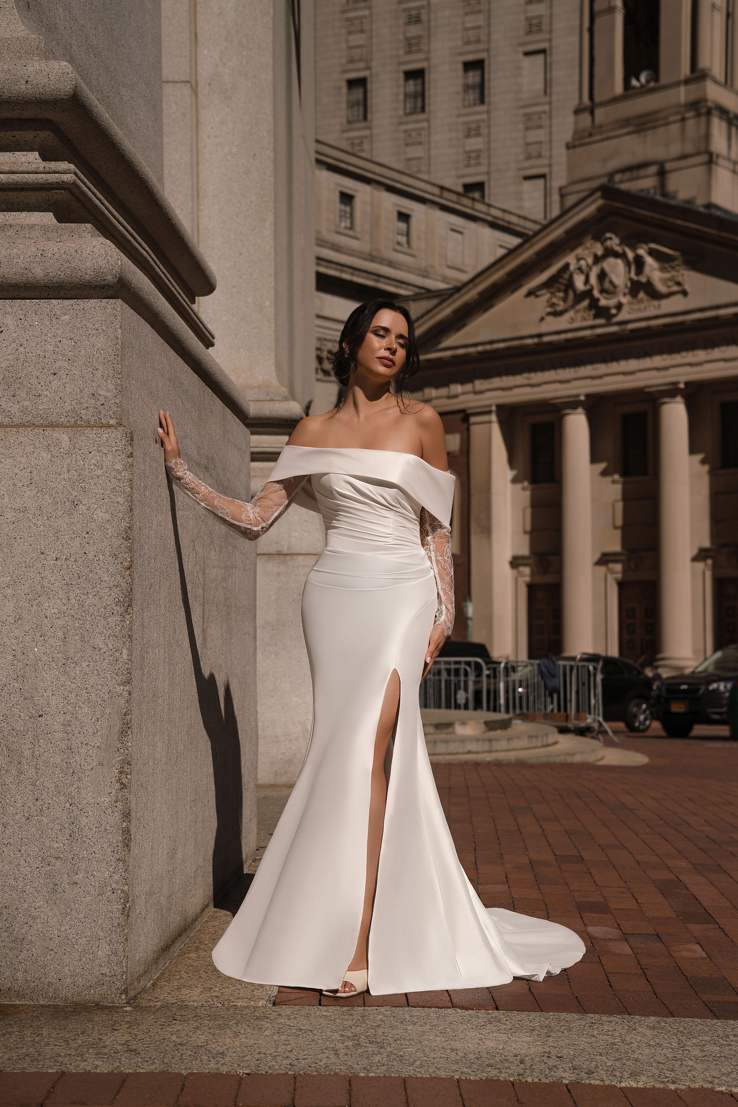Ivory mermaid wedding dress with an off-the-shoulder neckline, lace sleeves, and a high front slit