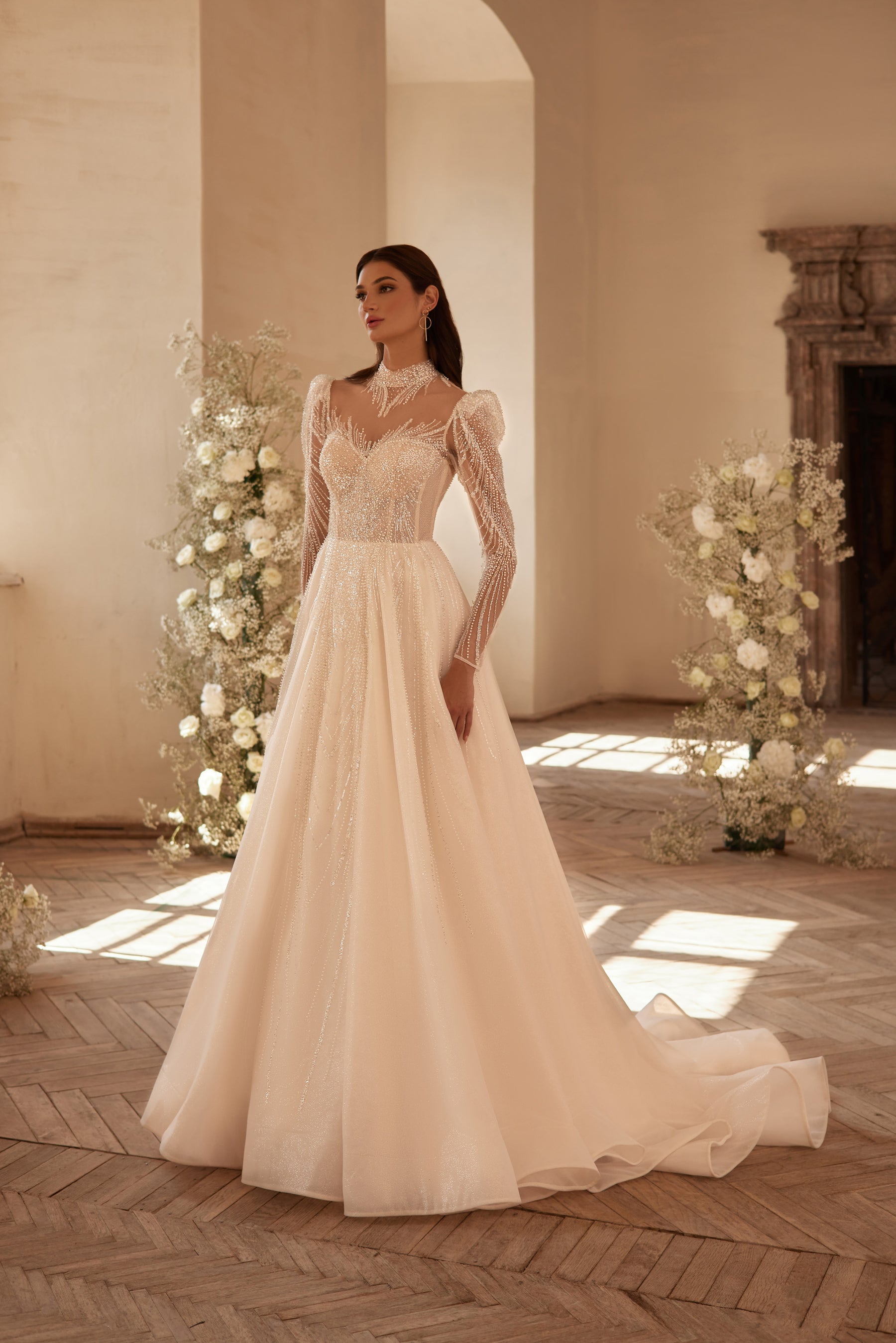Ivory A-line wedding dress with a beaded illusion high neckline, long sheer sleeves, and a full skirt