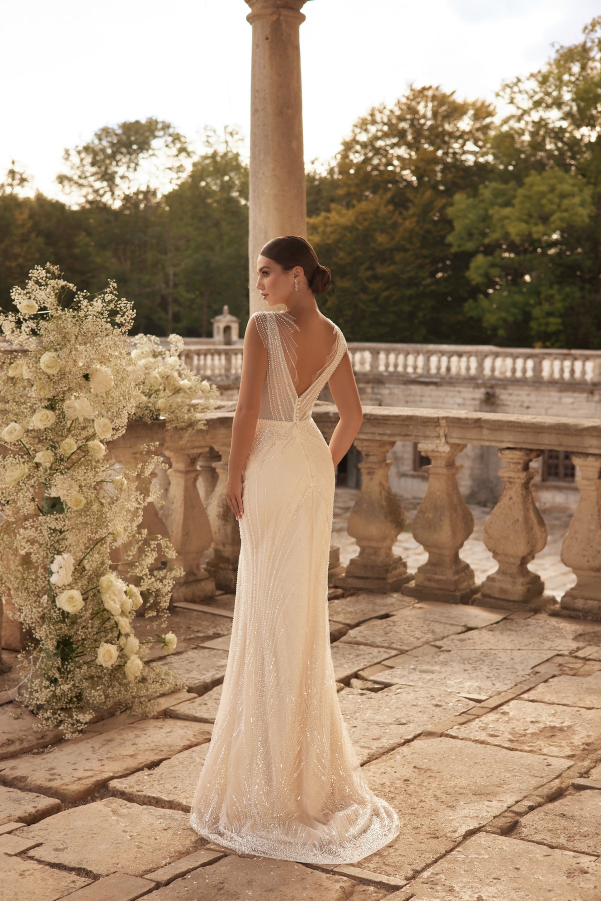 Ivory sheath wedding dress with a low V-back, sparkling beadwork, and a narrow hem train