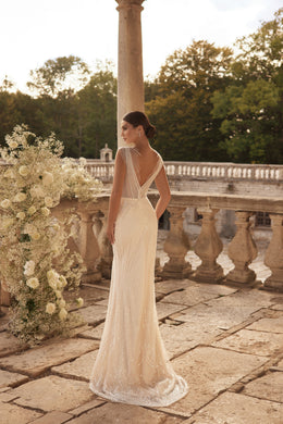 Ivory sheath wedding dress with a low V-back, sparkling beadwork, and a narrow hem train