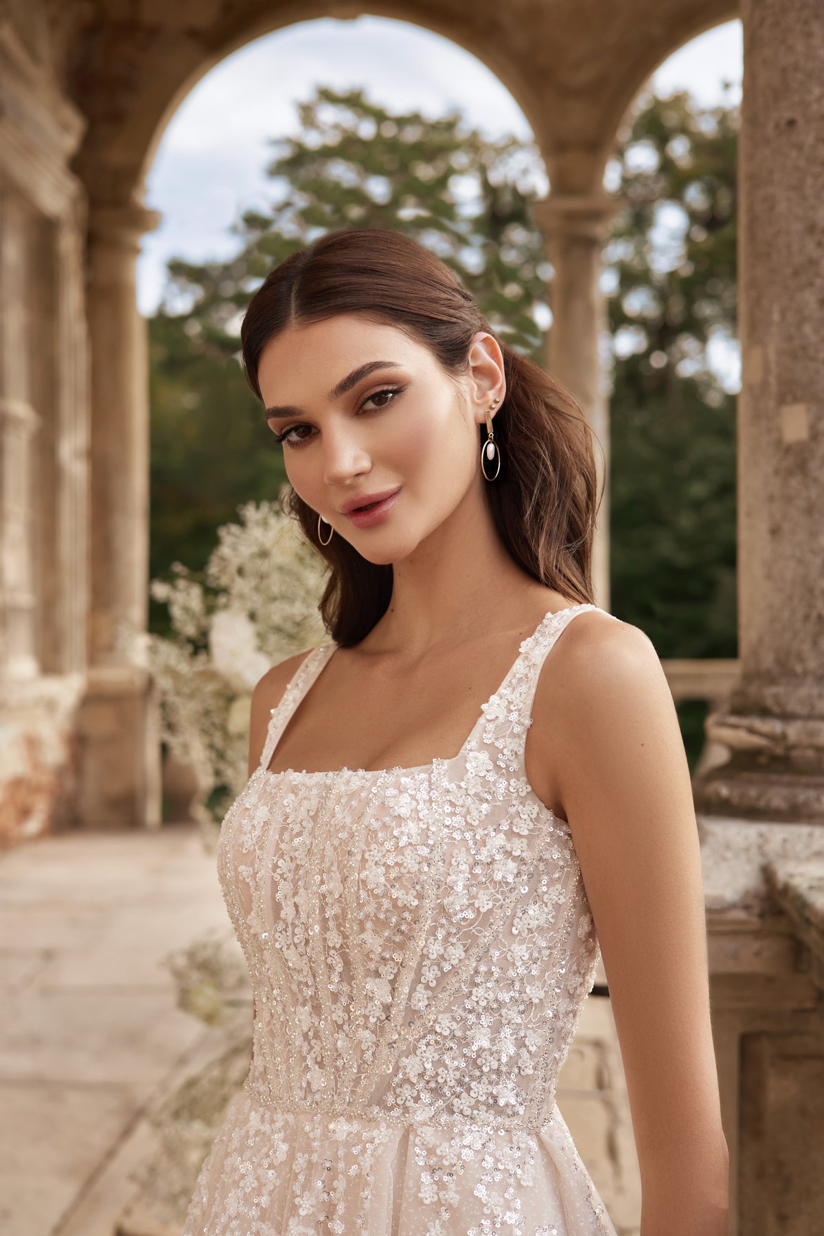 Close-up of a square-neck wedding dress bodice with floral sequins and wide shoulder straps