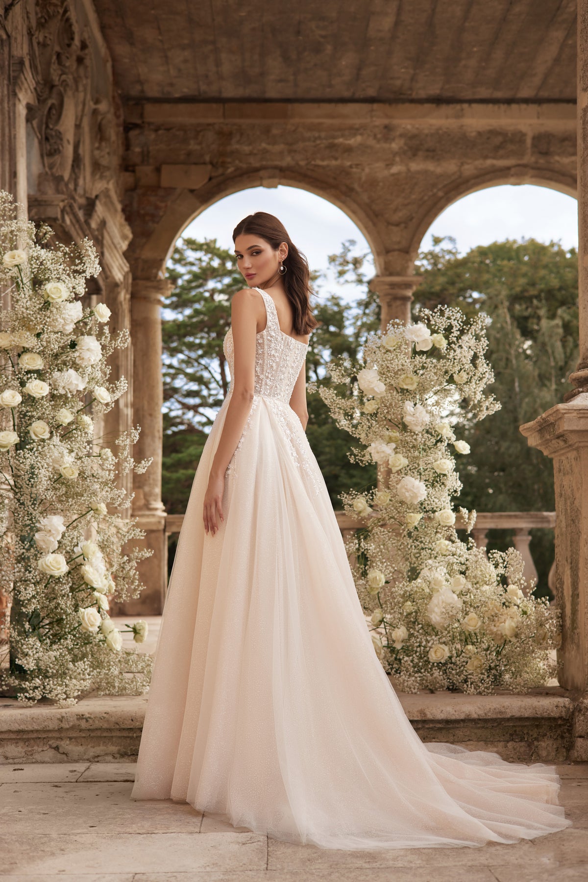 Ivory A-line wedding dress with a low square back, wide straps, and a long trailing train