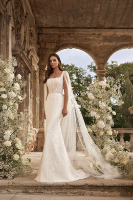 Ivory wedding dress with a square neckline, embellished bodice, sheer draped sleeves, and trailing train