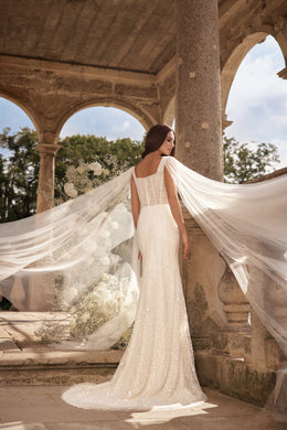 Back of an ivory wedding dress with a fitted silhouette and long sheer Watteau-style train
