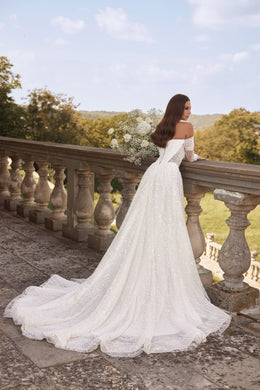 Back view of an ivory wedding dress with lace off-the-shoulder sleeves and a long, sweeping train