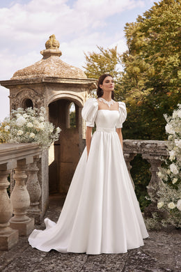 Ivory A-line wedding dress with a square neckline, short puff sleeves, and a flowing train