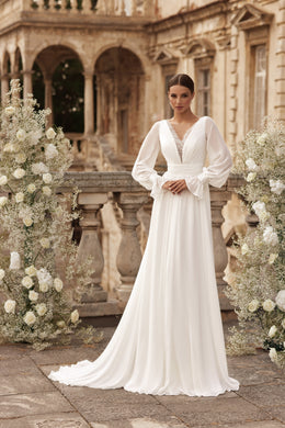 Ivory A-line wedding dress with a beaded V-neckline, sheer bishop sleeves, and a flowing train