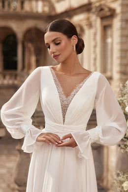 Close-up of an ivory wedding dress bodice with a beaded V-neckline, sheer bishop sleeves, and embellished cuffs