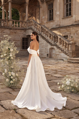 Open-back ivory wedding dress with an off-the-shoulder neckline, A-line skirt, and long train