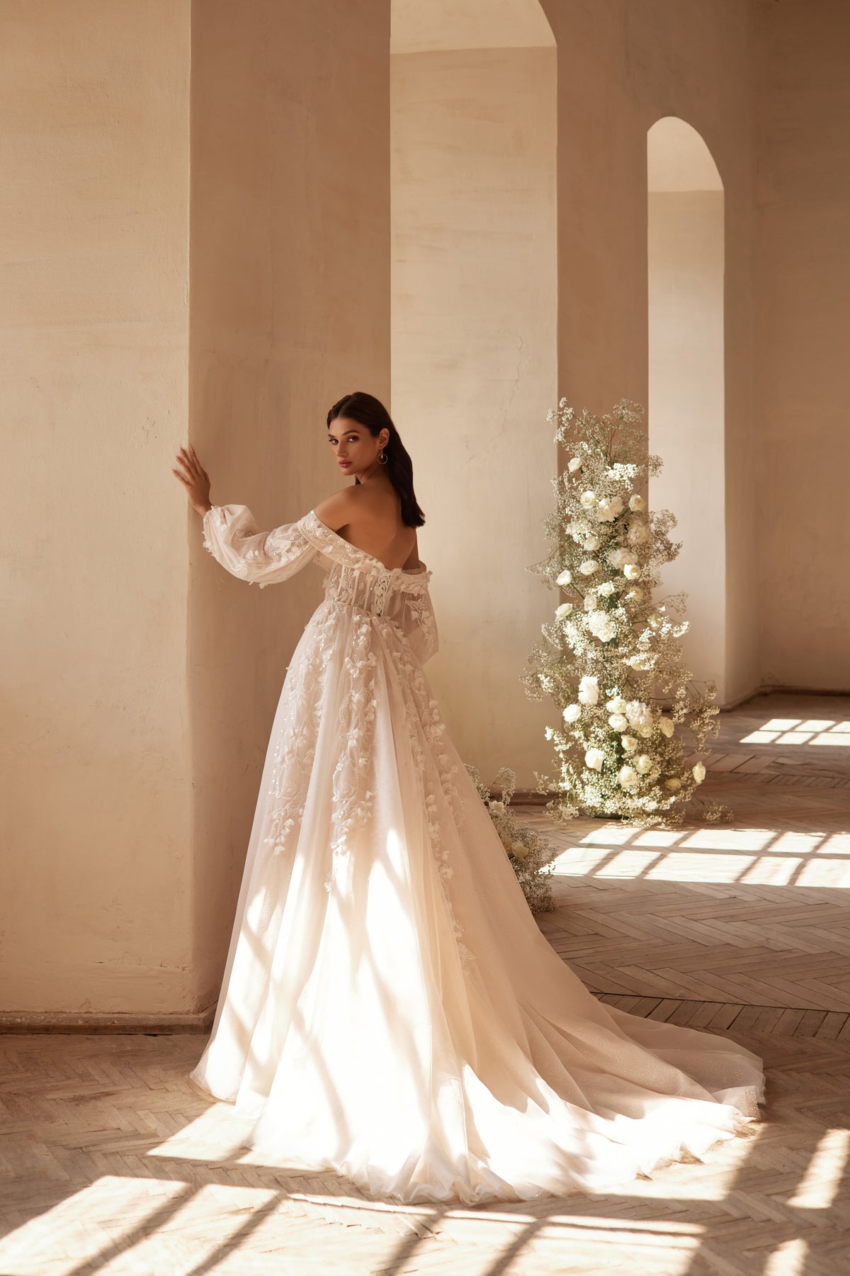 Ivory A-line wedding dress with off-the-shoulder sheer sleeves, floral appliqués, and a long train