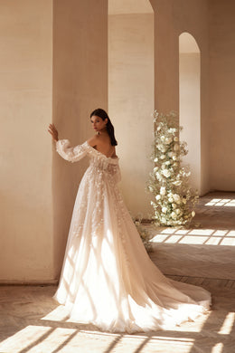 Ivory A-line wedding dress with off-the-shoulder sheer sleeves, floral appliqués, and a long train