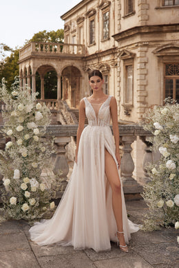 Ivory A-line wedding dress with a sheer plunging V-neck bodice, beaded lace, high slit, and long train