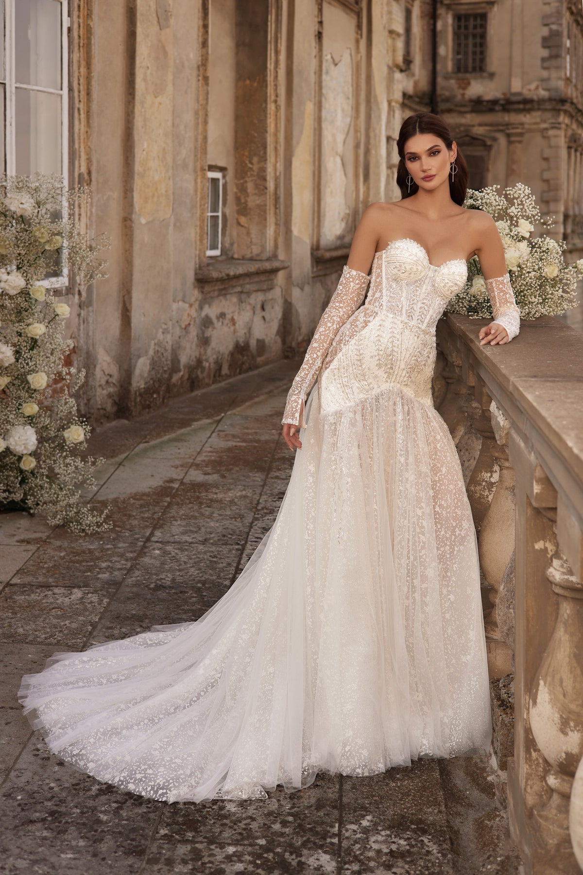 Ivory mermaid wedding dress with a sweetheart neckline, long lace sleeves, sparkling embroidery, and sweeping train