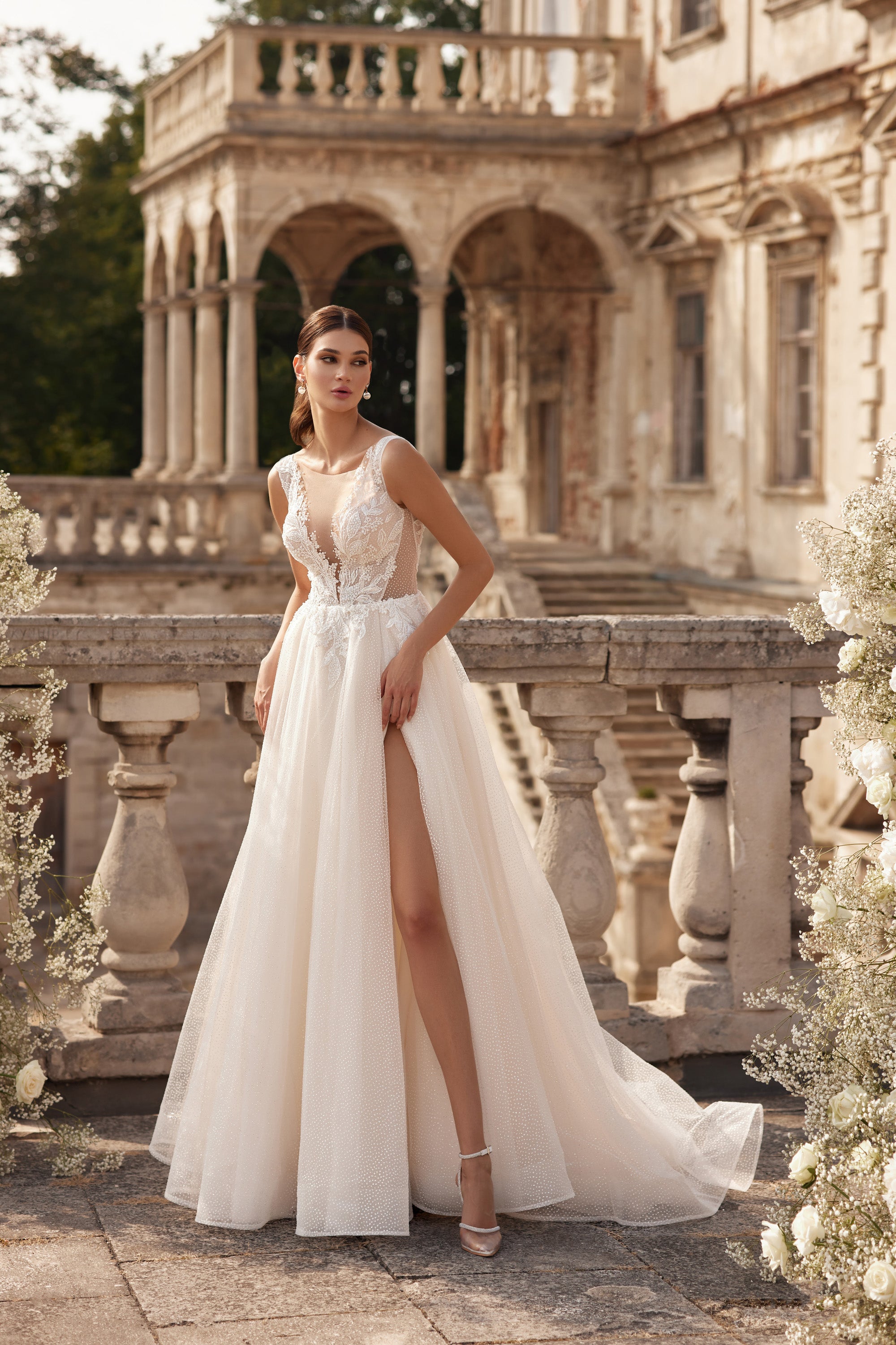 Ivory A-line wedding dress with a sheer V-neck bodice, floral lace, and a high front slit