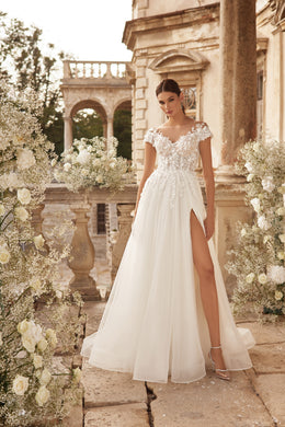 Ivory A-line wedding dress with an illusion lace neckline, cap sleeves, floral bodice, and high front slit