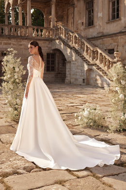 Ivory wedding dress with sheer lace back and sleeves, flowing A-line skirt, and a long train