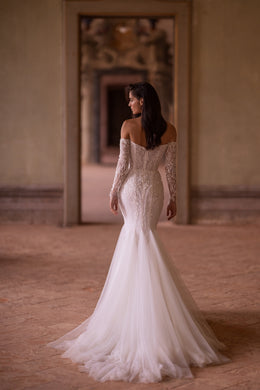 Ivory mermaid wedding dress showing a lace-covered back, off-the-shoulder sleeves, and a long flowing train