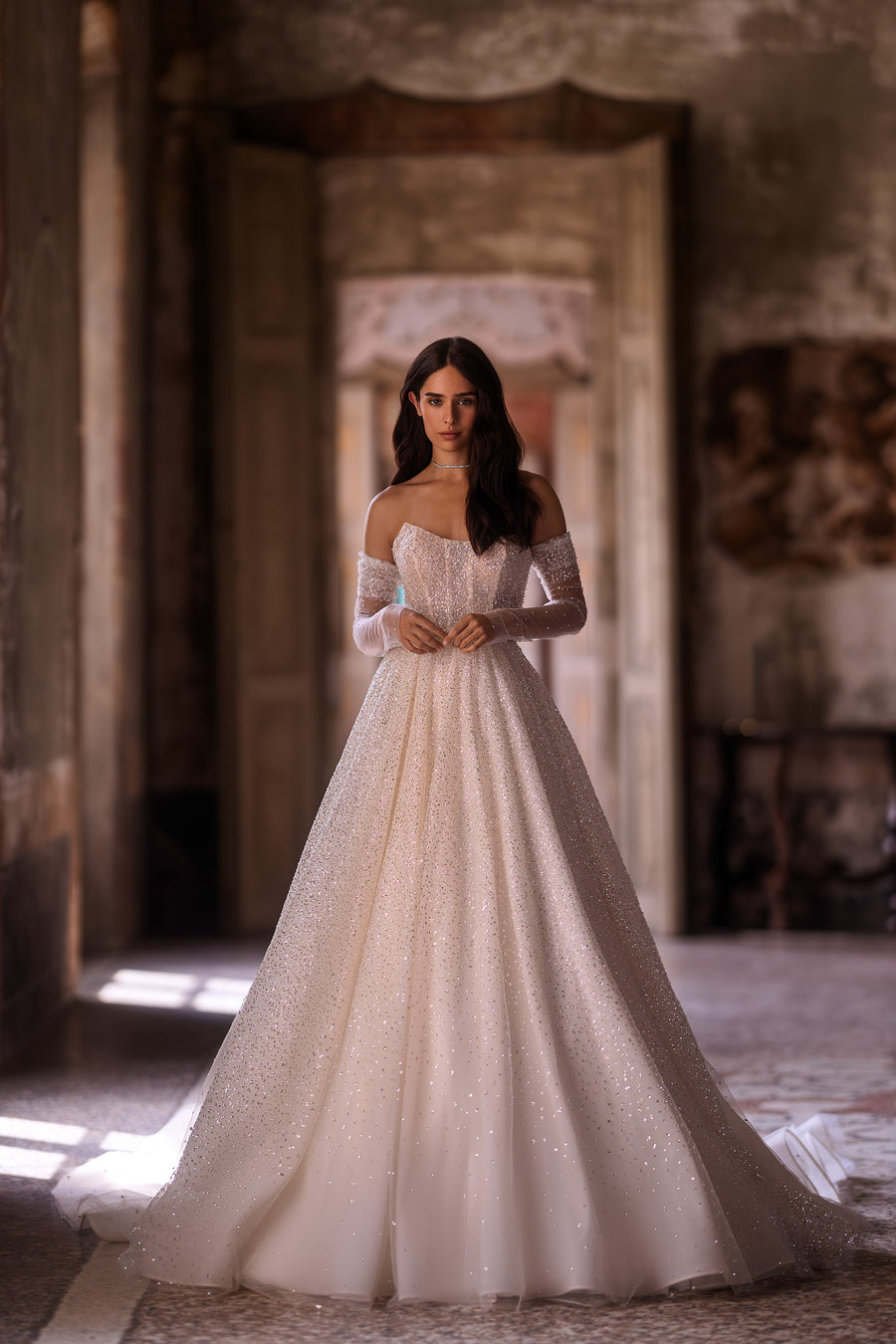 Ivory glitter A-line wedding dress with an off-the-shoulder neckline and sheer long sleeves
