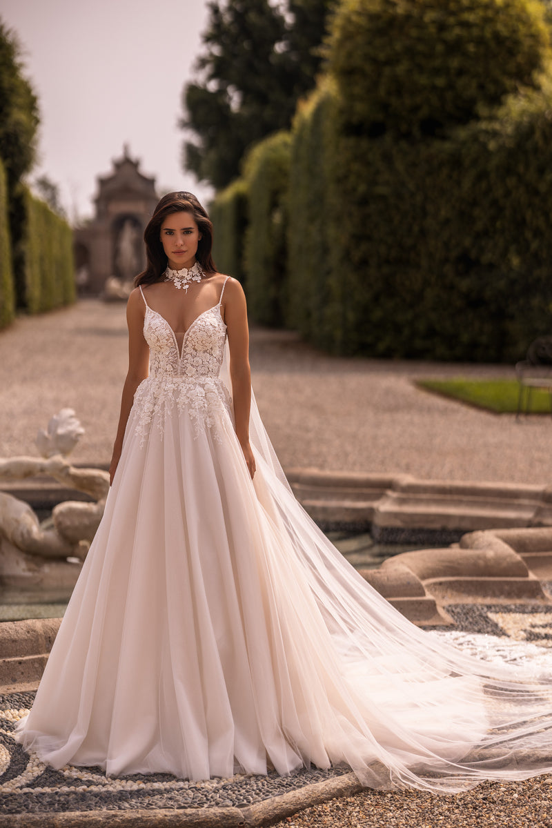 Ivory A-line wedding dress with a deep V-neckline, floral lace bodice, thin straps, and a long sheer train
