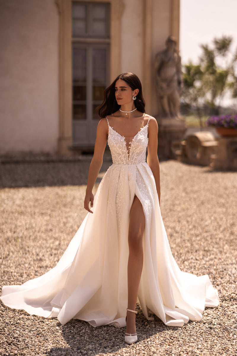 Ivory wedding dress with a V-neck lace bodice, thigh-high slit, and sweeping train