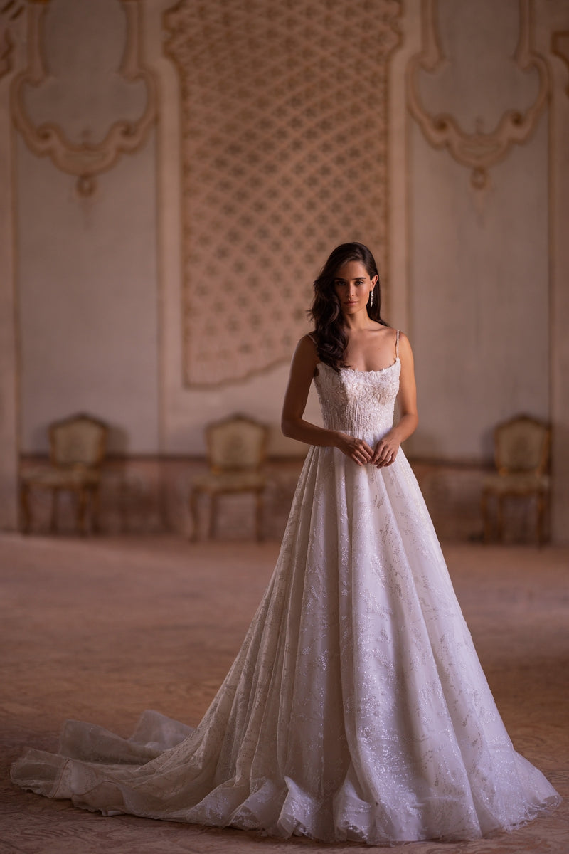 Ivory A-line wedding dress with beaded spaghetti straps, a square neckline, glittering skirt, and long train