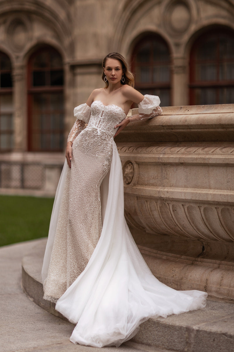 Ivory beaded lace mermaid wedding dress with a sweetheart neckline, sheer sleeves, and a long train