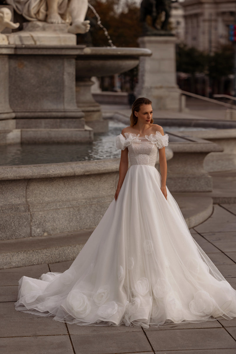 Ivory A-line wedding dress with an off-the-shoulder floral neckline, beaded bodice, and long train