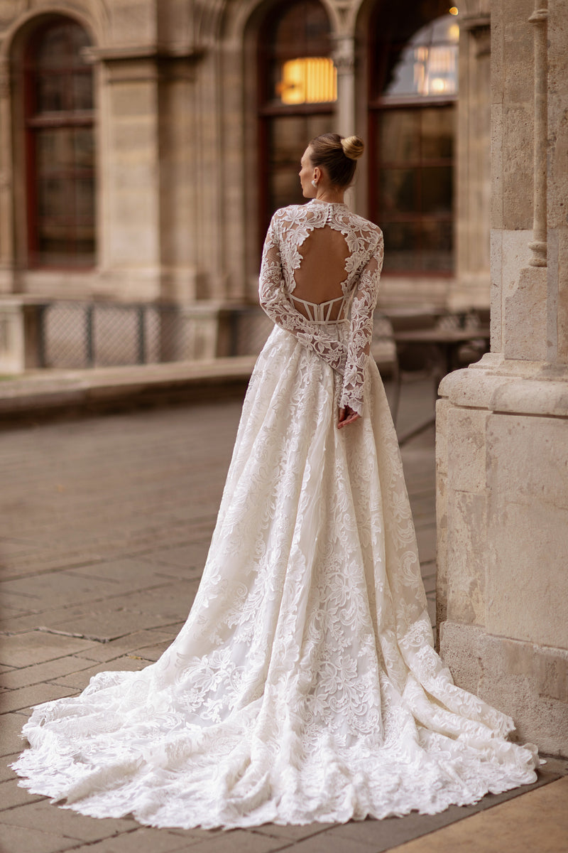 Open lace back with floral edging and long sleeves on an ivory A-line wedding dress with a long train