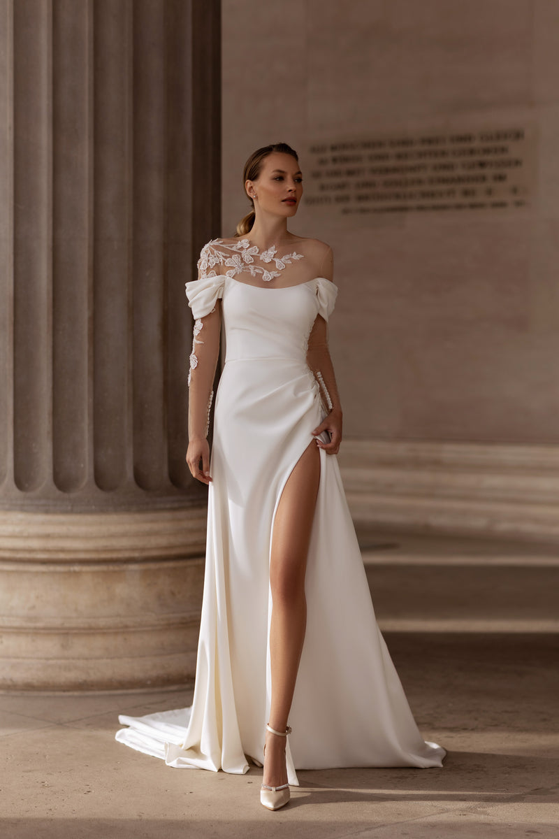 Ivory sheath wedding dress with off-the-shoulder sleeves, floral appliqué neckline, high slit, and train