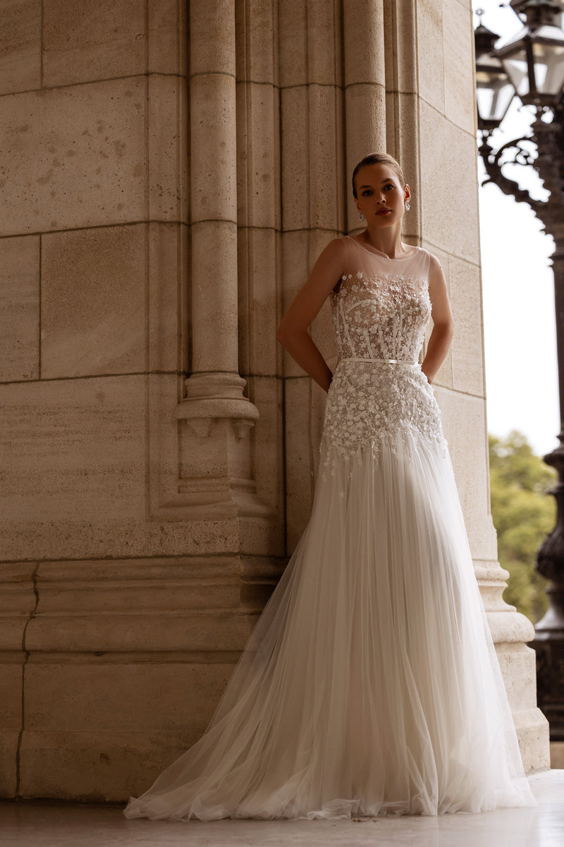 Ivory A-line wedding dress with floral lace bodice, sleeveless neckline, pleated skirt, and train