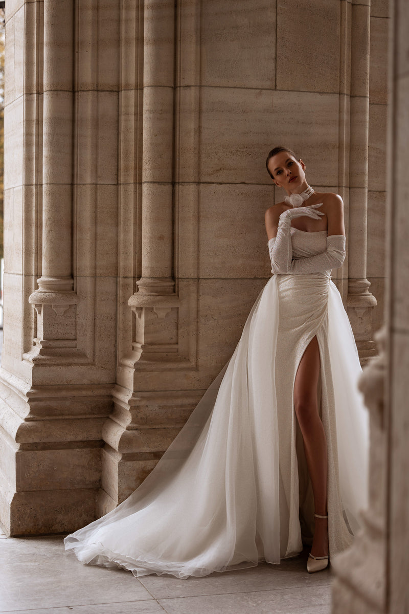 Strapless ivory wedding dress with a thigh-high slit, long gloves, and sweeping cathedral train