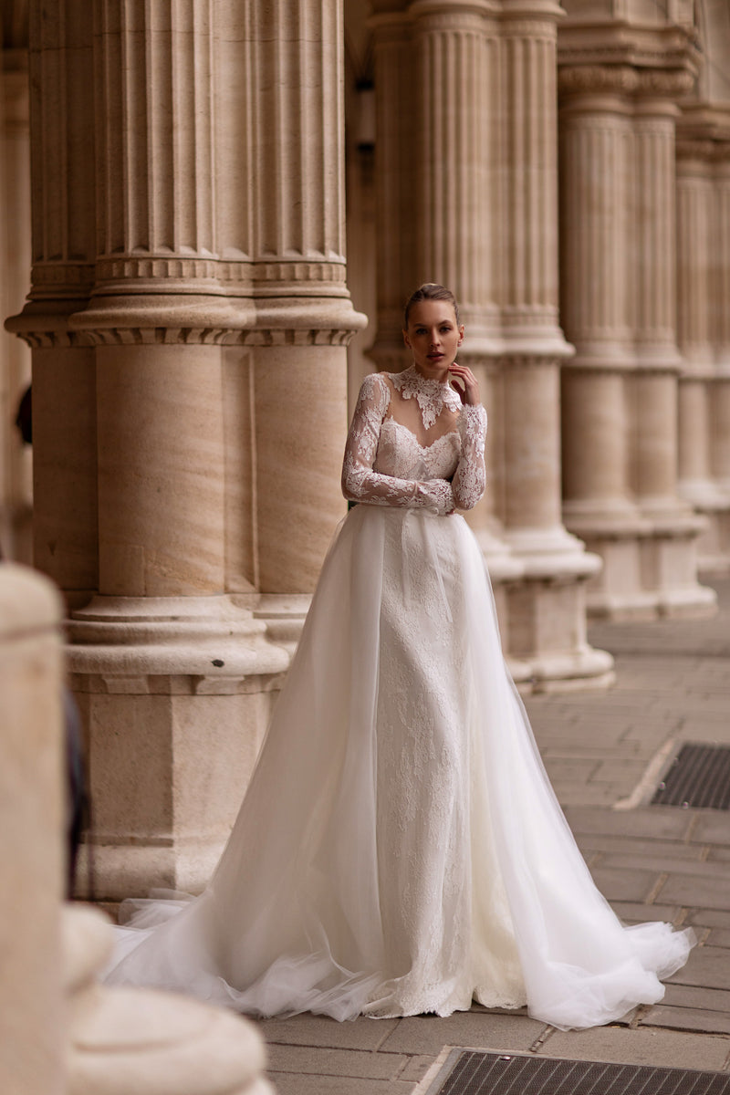 Ivory ball gown wedding dress with long lace sleeves, V-neckline, floral appliqués, and a sweeping train