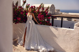 Full-length ivory wedding dress with a flowing A-line skirt, thigh-high slit, and sweeping train