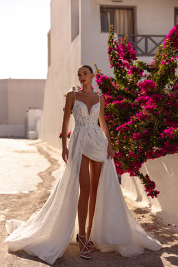 Ivory wedding dress with a beaded V-neck bodice, dramatic front slit, flowing overskirt, and train