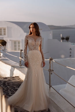 Fitted ivory wedding dress with a bateau neckline, sheer embellished sleeves, and a softly flared train