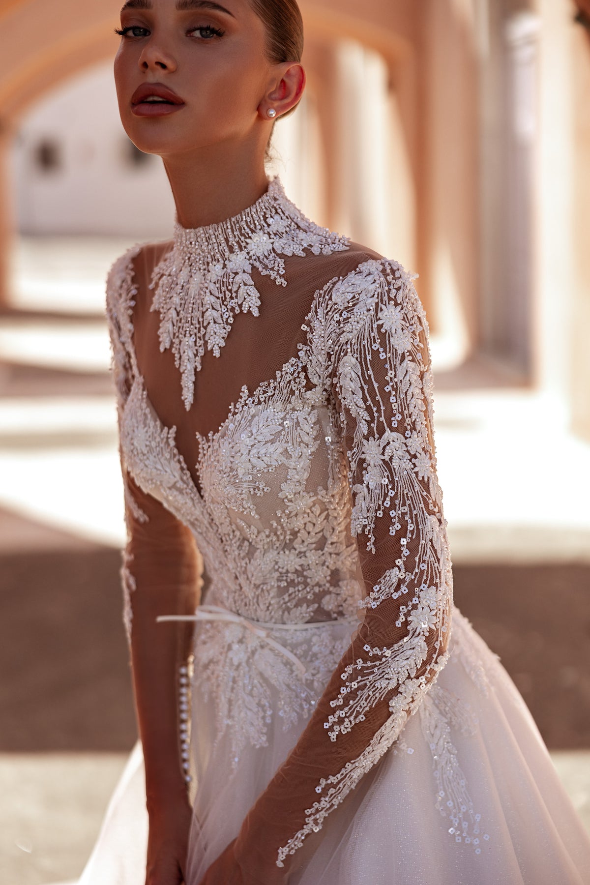 Ivory A-line wedding dress with a high illusion neckline, sheer lace sleeves, and floral lace bodice