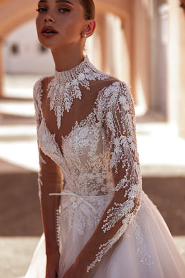 Ivory A-line wedding dress with a high illusion neckline, sheer lace sleeves, and floral lace bodice