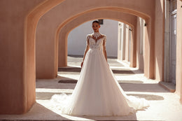 Ivory A-line wedding dress with a high neckline, long sheer lace sleeves, and a full flowing skirt